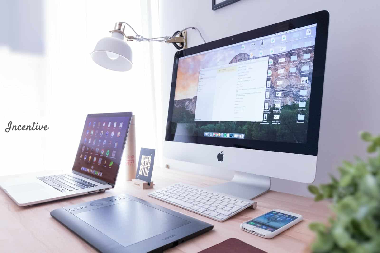 silver iMac near iPhone on brown wooden table