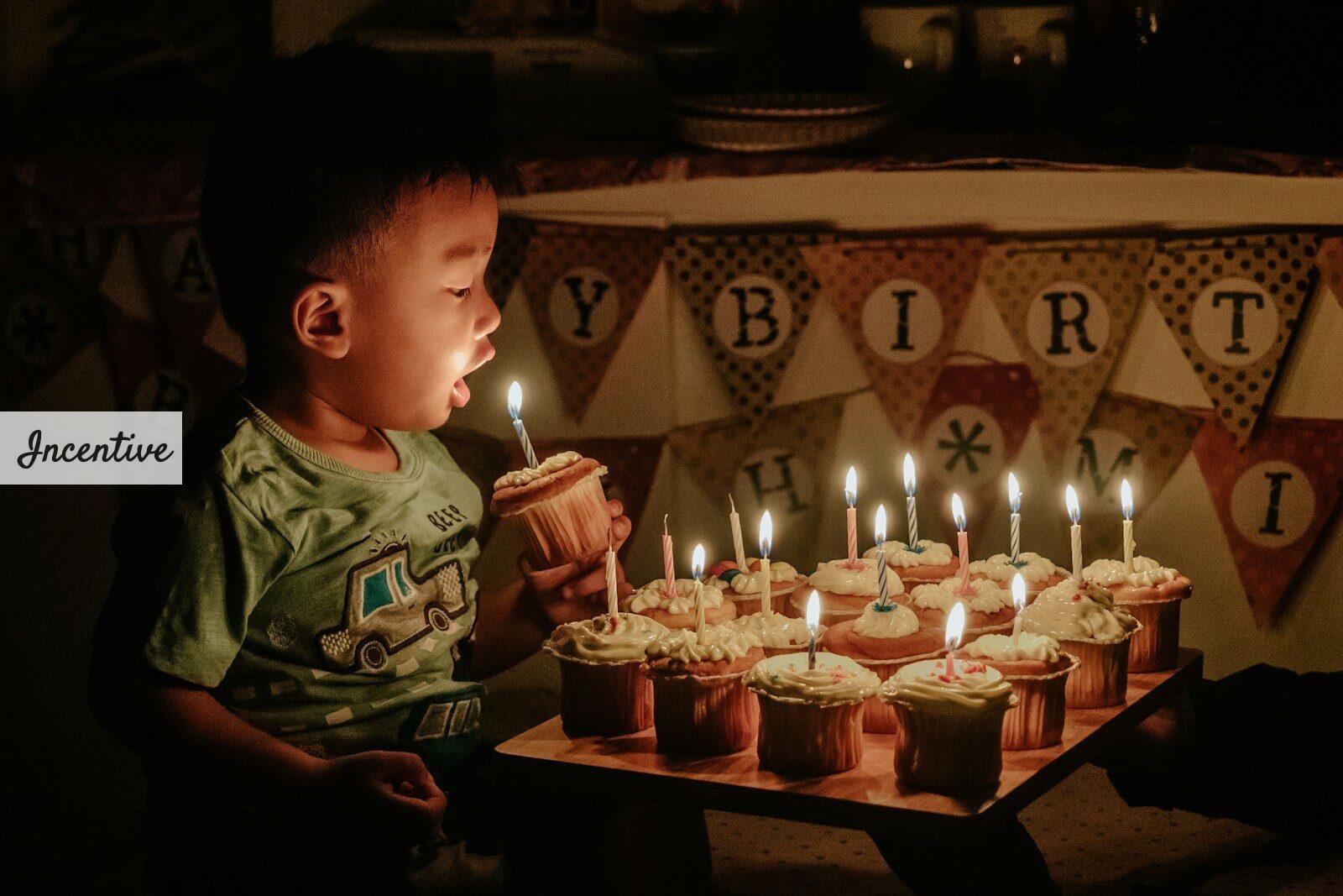 boy holding cupcake blowing the candle